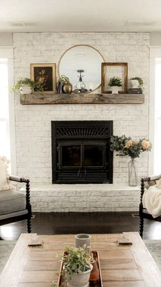 a living room filled with furniture and a fire place in front of a white brick wall