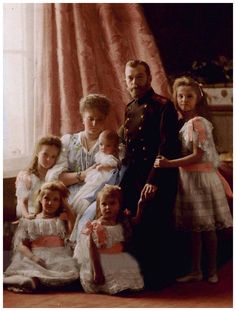 an old photo of a family posing for a picture in front of a window with pink curtains