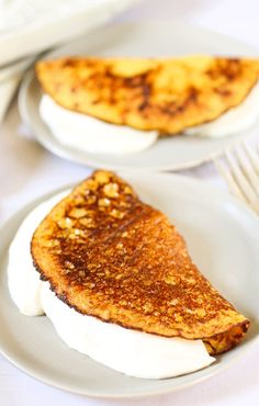 two white plates topped with french toast and whipped cream