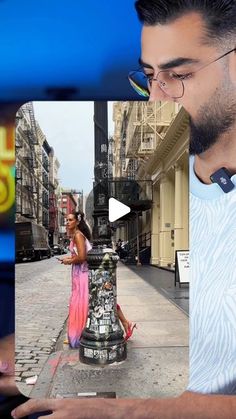 a man is looking at his cell phone while standing next to a fire hydrant