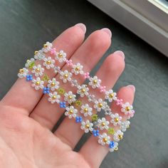 someone is holding some tiny flowers in their hand and it looks like they have been made out of beads