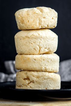 three biscuits stacked on top of each other on a black plate with a gray background