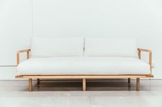 a white couch sitting on top of a wooden frame