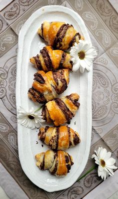 several pastries on a white plate with flowers