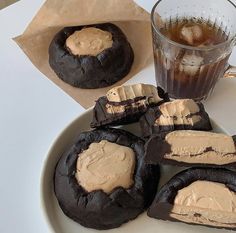 chocolate cookies with peanut butter frosting on a plate next to a glass of iced tea