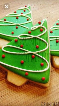 two decorated christmas cookies sitting on top of a wooden table