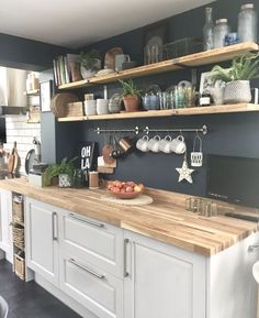 a kitchen with open shelving and wooden counter tops