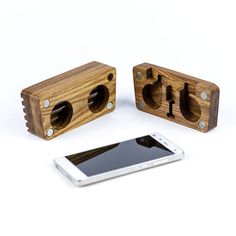 two wooden speakers sitting next to an iphone