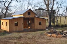 a small wooden building in the middle of a field