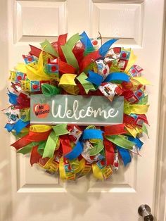 a welcome sign is hanging on the front door with colorful streamers and ribbons around it