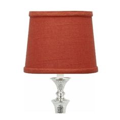 a lamp that is on top of a table with a red lampshade next to it