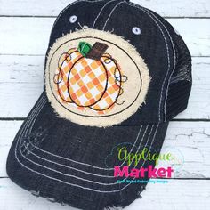 a black hat with an orange and white pumpkin patch on it