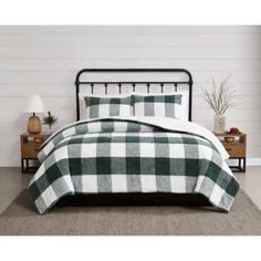 a bed with green and white plaid comforter