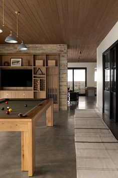 a pool table is in the middle of a room with built - in shelving