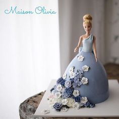 there is a cake made to look like a woman in a blue dress with flowers on it