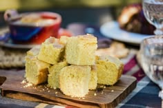 a wooden cutting board topped with pieces of cake