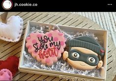 two decorated cookies in a box with the words you stole my heart written on them