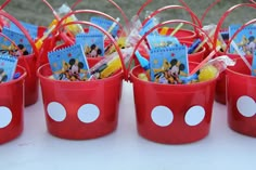 red buckets filled with mickey mouse party favors