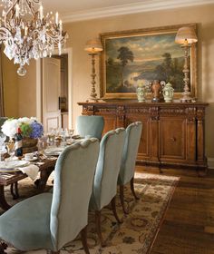 a dining room table with blue chairs and a chandelier