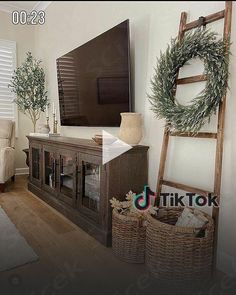 a living room with a large flat screen tv sitting on top of a wooden entertainment center