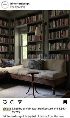 a couch sitting in front of a bookshelf filled with lots of book shelves