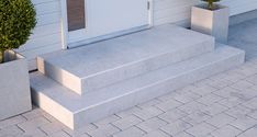 two cement planters sitting next to each other on the side of a white building