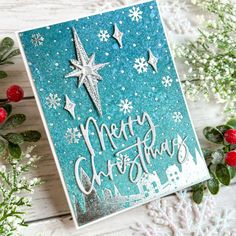 a christmas card with snowflakes and stars on it, surrounded by holly branches