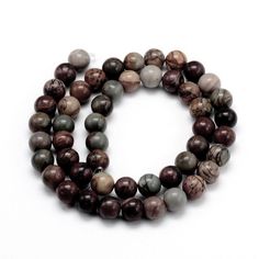 two strands of brown and white marble beads on a white surface with one bead in the middle