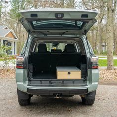 the back end of a vehicle with its trunk open and an empty box in it