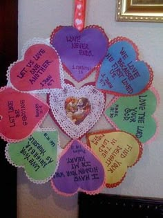 a heart shaped decoration hanging from the side of a wall with words written on it