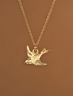 Sparrow necklace, little bird necklace in gold, swallow necklace, flying bird jewelry, a gold vermeil sparrow on a 14K gold vermeil chain A precious little gold vermeil swallow pendant hangs peacefully from a 14K gold vermeil chain in the length of your choice! Need an energy boost for your necklace? You can also add a little tourmaline drop if you like! https://www.etsy.com/listing/156969259/tourmaline-drop-energy-boost-add-a?ref=shop_home_active Looking for other charm necklaces? https://www.e Gold Bird Necklace, Gold Pendant Necklace With Bird Design, Gold Bird-shaped Jewelry With Bird Design, Sparrow Jewelry, Sparrow Necklace, Gold Baubles, Swallow Necklace, Flying Bird, Tiny Bird