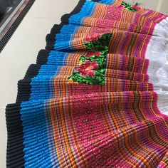 several rows of colorful knitted bedspreads lined up on the floor next to each other