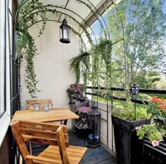 an outdoor patio with wooden furniture and potted plants