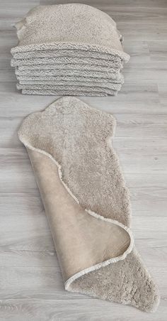 a pile of white towels sitting on top of a wooden floor next to each other