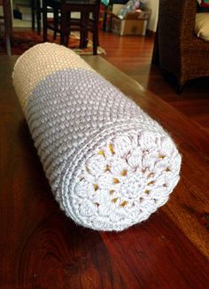 a white crocheted blanket laying on top of a wooden floor