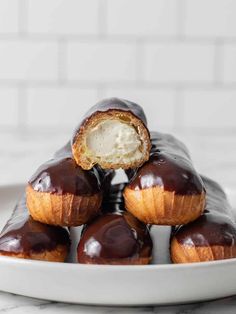 chocolate covered doughnuts stacked on top of each other with one bite taken out