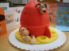 there is a cake made to look like a rocket ship with a baby in it