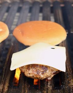 hamburgers and buns cooking on an outdoor grill