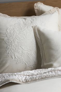 two white pillows sitting on top of a bed