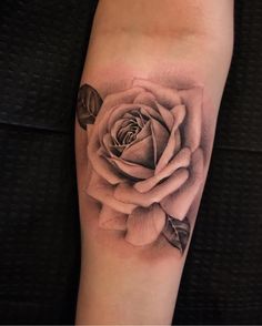 a black and white rose tattoo on the arm