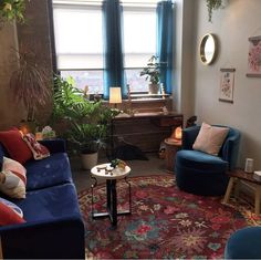 a living room filled with blue couches next to a large rug on top of a hard wood floor