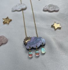 These cute celestial cloud necklaces will brighten up any day, rain or shine! This necklace features an adorable pearlized raincloud with engraved detail and a glitter and mirrored gold sunbeam! We have also added our new autumn skies sunbeam necklace in a pink, glittery tone. You can then choose to add the Iridescent raindrops for an extra sweet feature. The pendant measures 3cm in width which makes it wearable for all occasions and is complimented with a gold plated adjustable chain. Each one is lovingly made and designed in my home studio and will arrive in a presentation box and gift wrapped. Cute Jewellery, Cloud Necklace, Necklace Cute, Rainbow Necklace, Rain Or Shine, Rain Drops, Cute Jewelry, Jewelry Necklace Pendant, Jewelry Necklaces