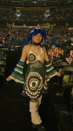 a woman with blue hair is standing in front of an audience