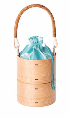 a bamboo basket with a drawstring handle and handles on the side, filled with blue