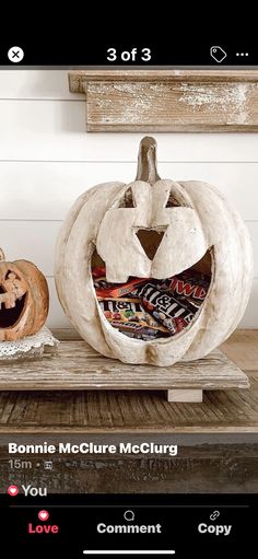 two carved pumpkins sitting on top of a wooden table