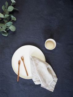 a white plate topped with two wooden utensils