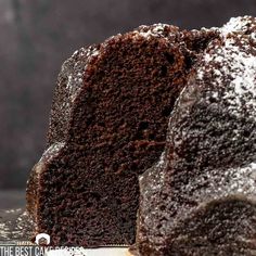 a chocolate cake with powdered sugar on top and one slice cut out from it