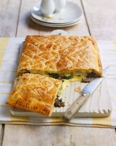 there is a pie that has been cut in half on the table with a knife next to it