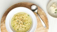 a bowl of macaroni and cheese soup on a wooden tray