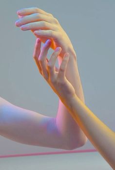 two hands reaching up to touch each other's arm, with the light shining on them